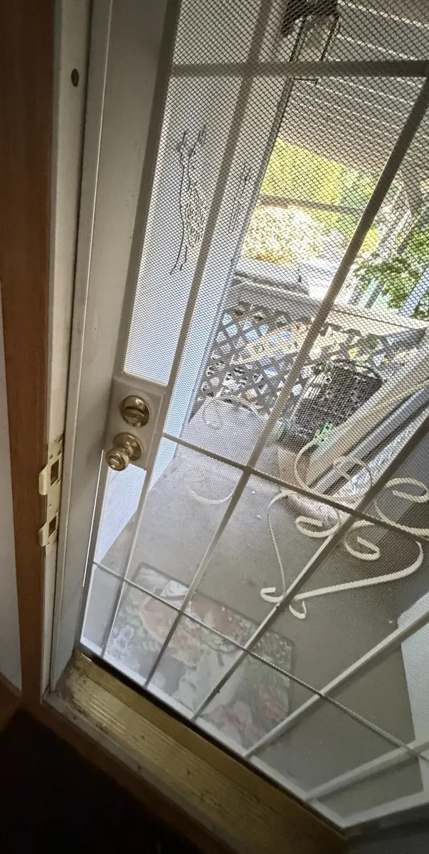 Close-up of new deadbolt and handle hardware on the security screen door