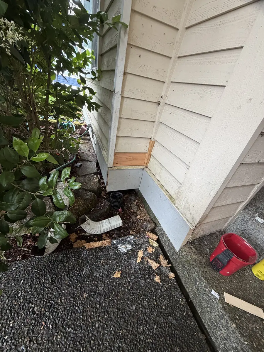 New wood replacement piece installed at the base of an exterior corner trim board